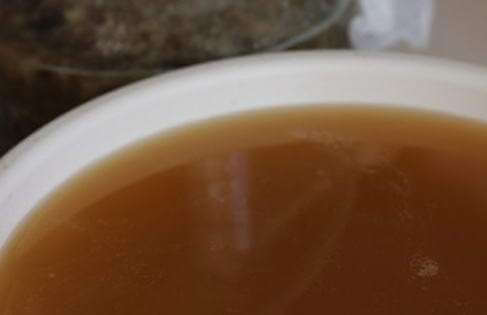 Процеживание первого кваса через марлю